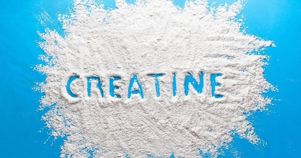The term "creatine" formed from white powder on a blue backdrop, showcasing the product's essence and visual appeal.