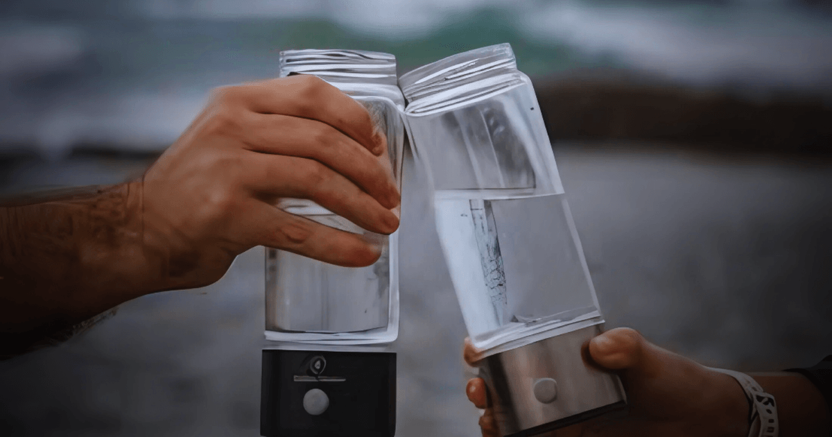 Two individuals stand by the ocean, each holding a water bottle, enjoying the scenic view together.