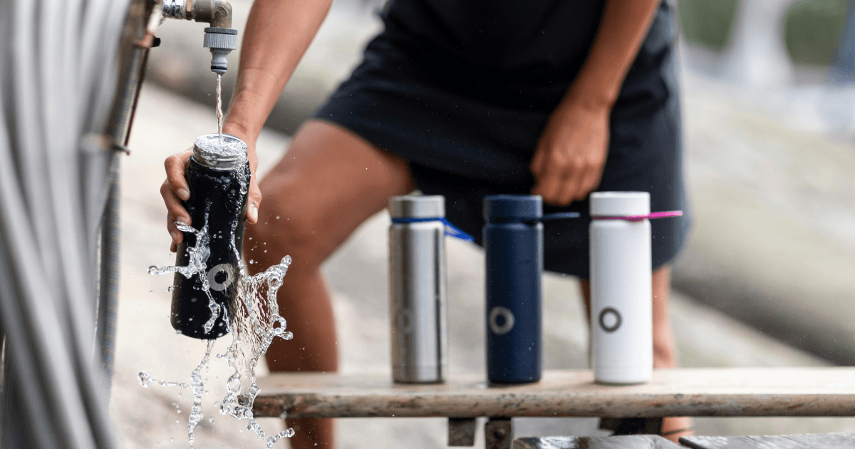A man fills a water bottle from a tap, emphasizing the importance of staying hydrated and using sustainable containers.