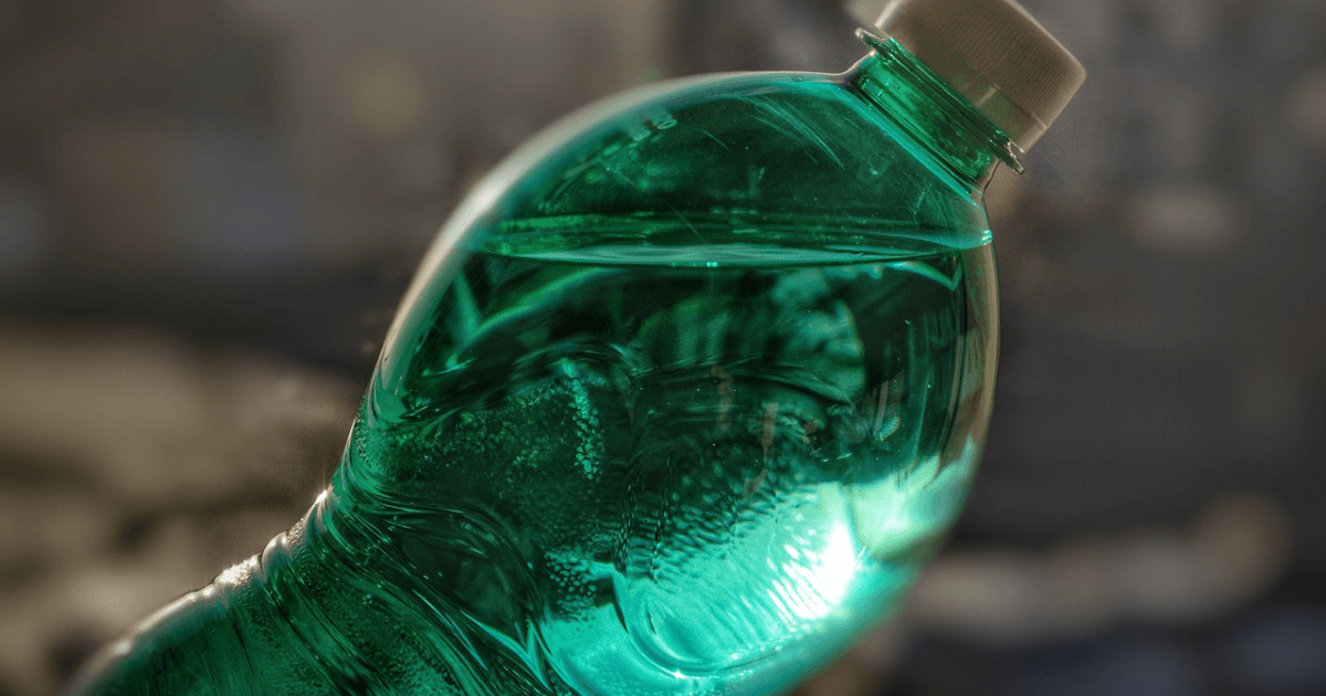 A bottle filled with a green liquid, showcasing its vibrant color against a neutral background.