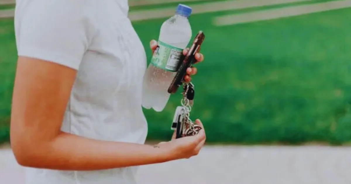 A girl carrying piggly wiggly bottled water.