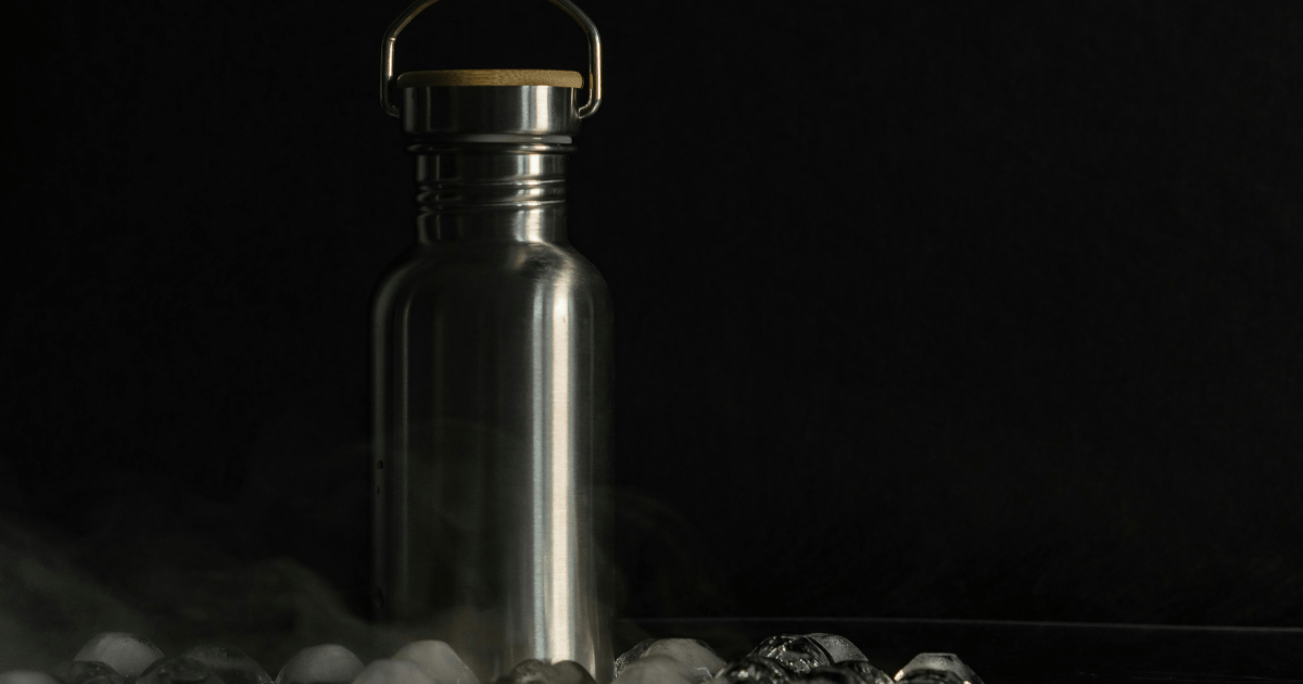 A stainless steel water bottle filled with ice, reflecting light and showcasing its sleek design.