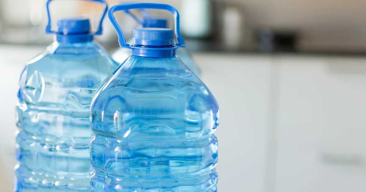 Three plastic bottles of water arranged neatly on a table, showcasing their clear contents and labels.