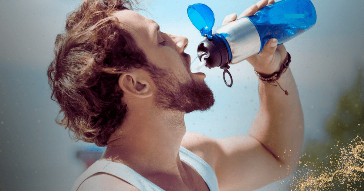 A man is hydrating by drinking water from a blue water bottle, showcasing a moment of refreshment and wellness.